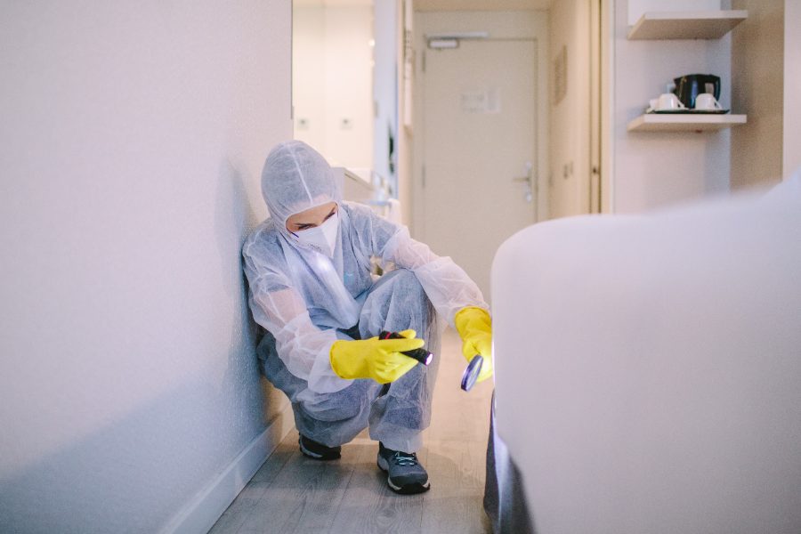 Técnica con EPI inspeccionando el perímetro de una habitación